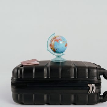 A globe placed on a black suitcase symbolizing global travel and adventure.